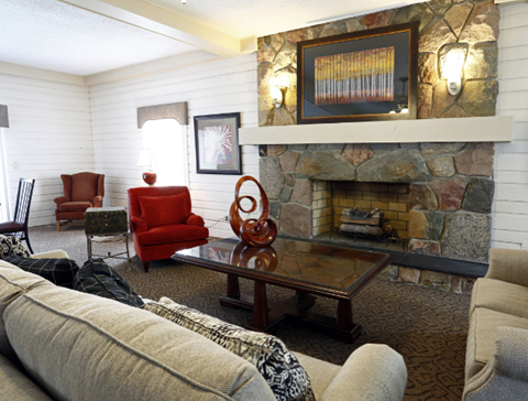 the living room has a large stone fireplace and couches